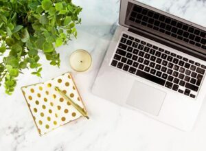 gold notebook with laptop