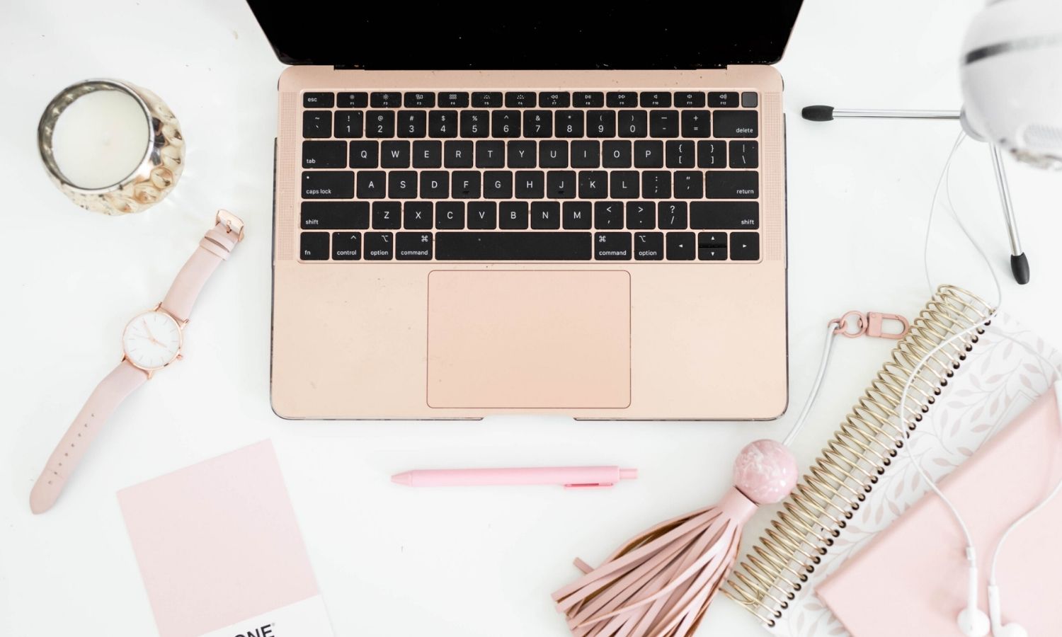 blush laptop and accessories on a white desk