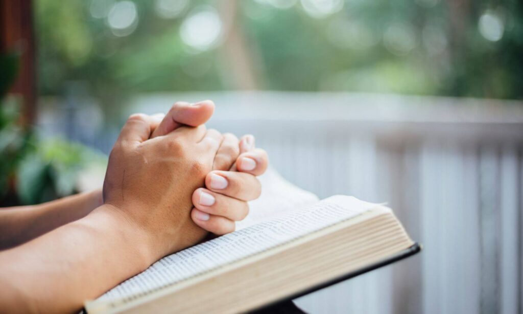 praying hands on Bible